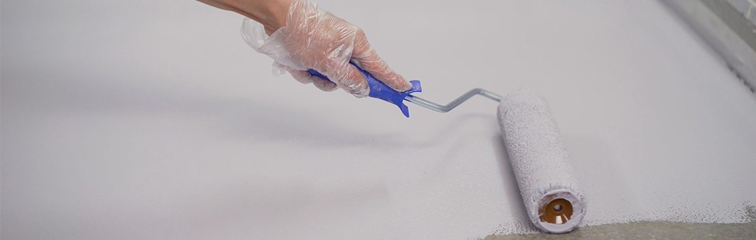 off-white paint being rolled out on a garage floor